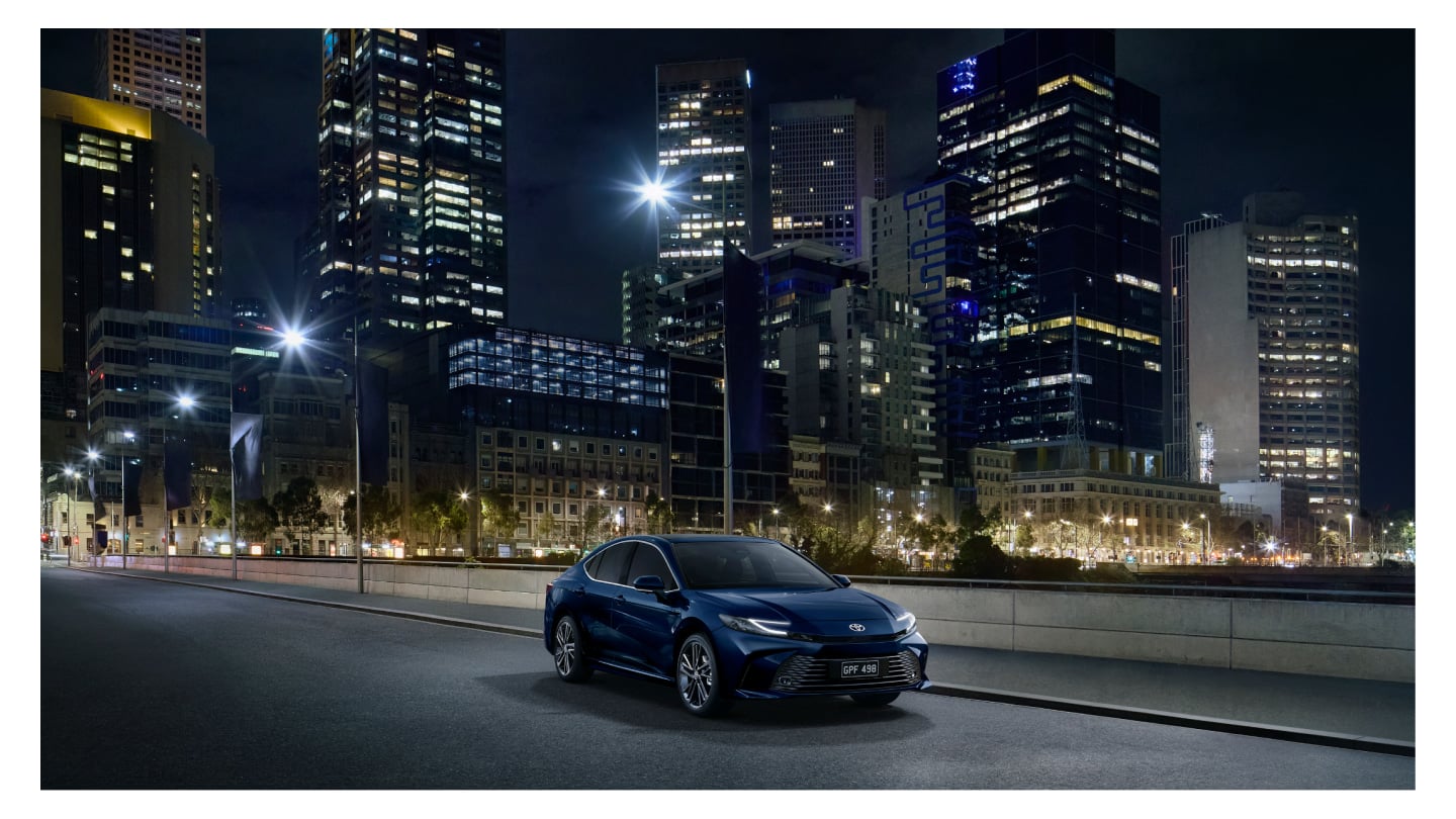 A sleek new Toyota Corolla parked in front of a vibrant city skyline, showcasing modern design and urban vibes.