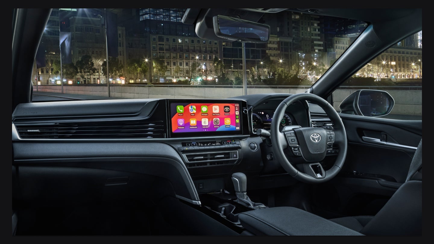 Toyota Camry navigates a bustling city street, showcasing its sleek design and urban adaptability.