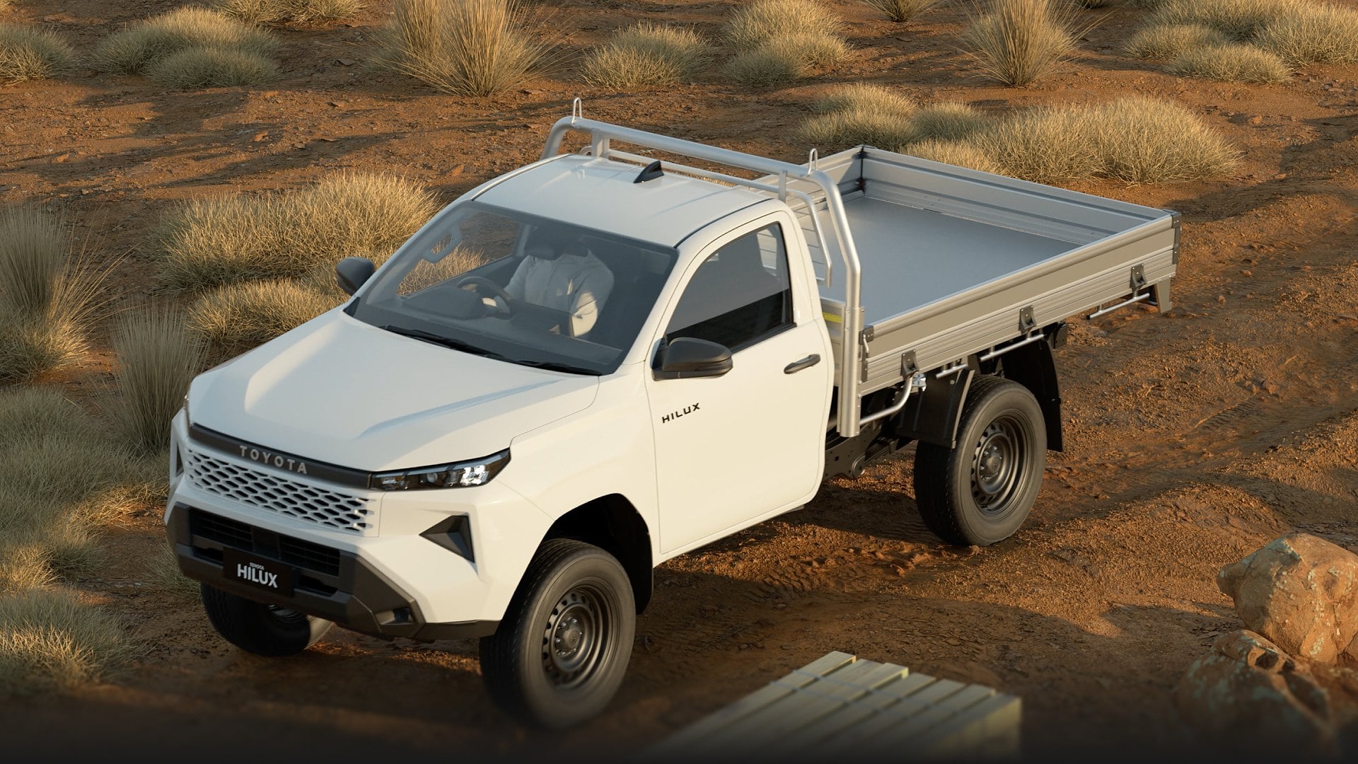 A white, extra-cab HiLux ute with a steel tray is parked on a regional track during golden hour, surrounded by native grasses and rust-coloured dirt. A man in a white shirt is partially visible in the driver’s seat.